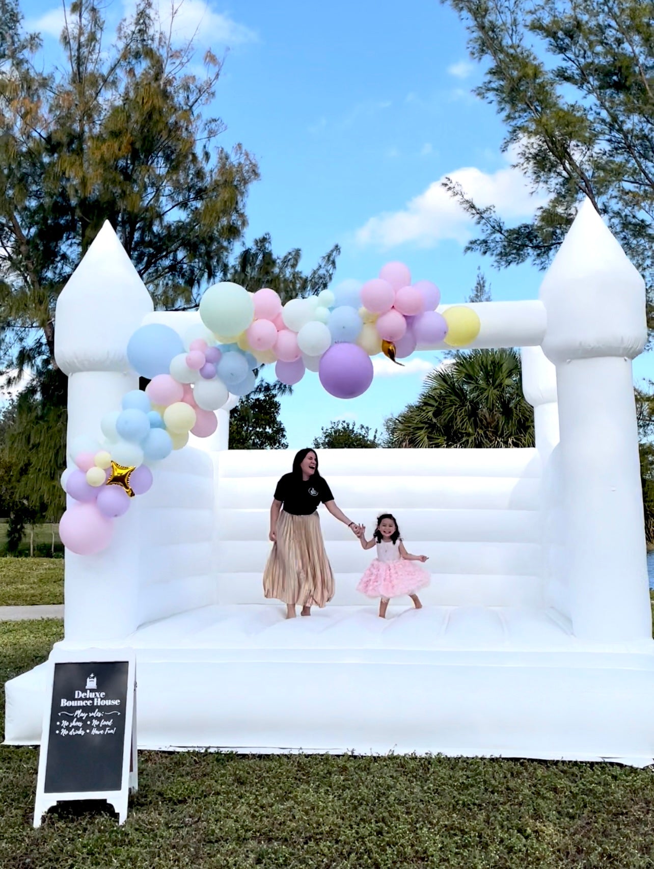 White Bounce House for rent, bounce house decor, ballon garland decor, free delivery miami dade and broward county, beautiful bounce house, castle bounce house, party decor, mom and daughter jumping, happy family, birthday with bounce house decor